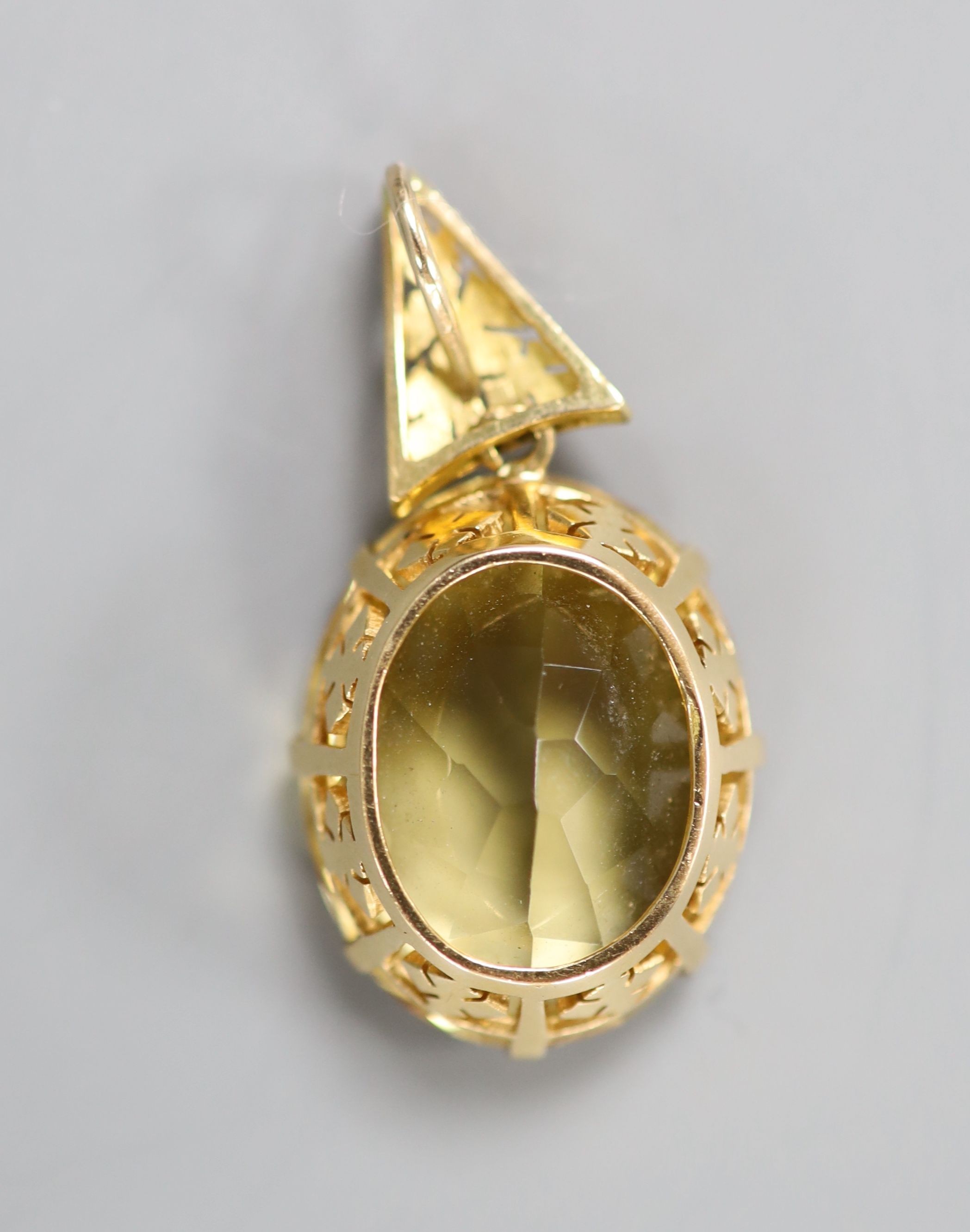 A yellow metal mounted oval citrine pendant, overall 39mm, citrine length 25mm, gross weight 10.8 grams.